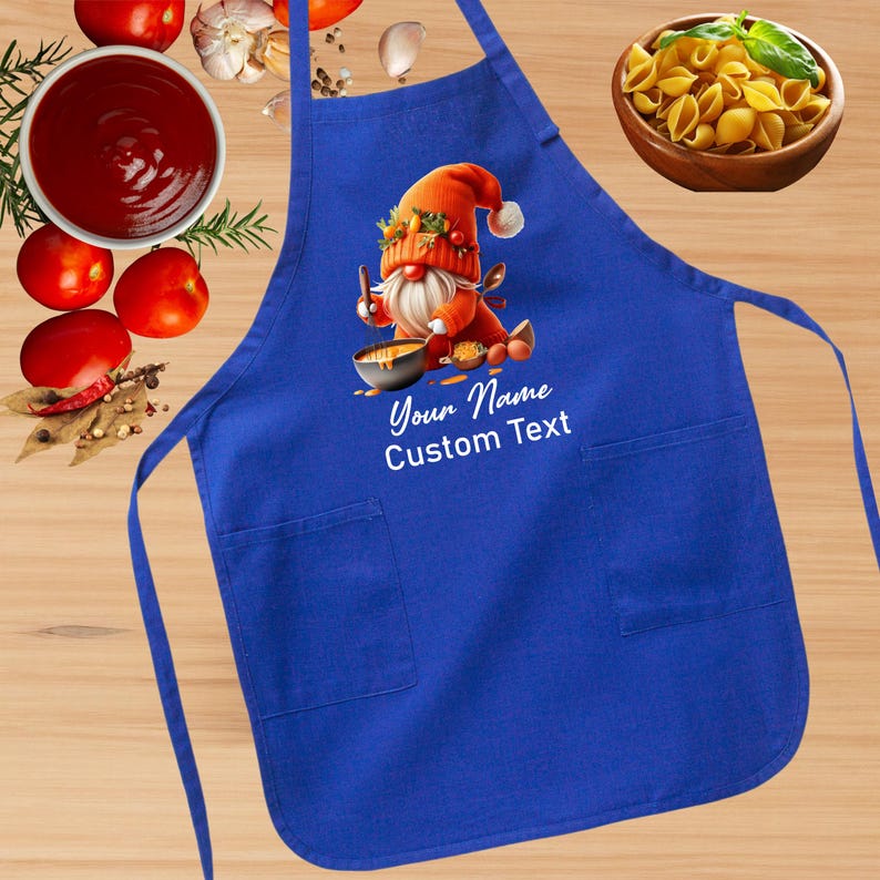May include: Blue kitchen apron with a gnome cooking in a pot. The apron has two pockets and the text "Your Name Custom Text".