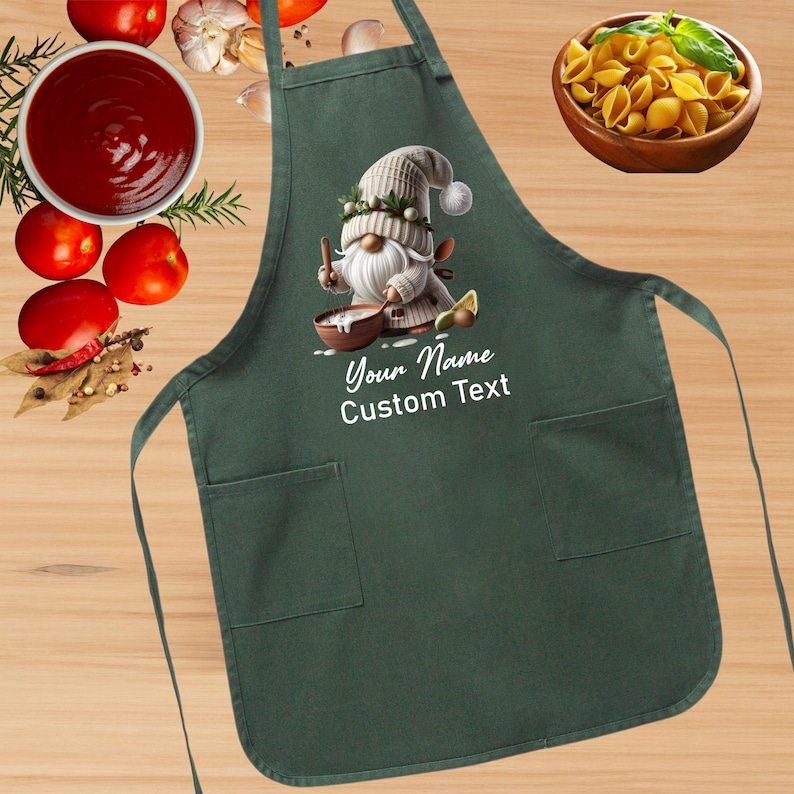 May include: Green kitchen apron with a white gnome illustration holding a bowl and spoon. The text "Your Name Custom Text" is printed on the apron.