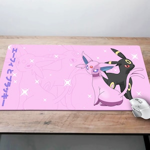 May include: Pink and black mousepad with a graphic of two Pokemon characters, a pink Espeon and a black Umbreon. The text "エスペオンとブラッキー" is printed on the left side of the mousepad.