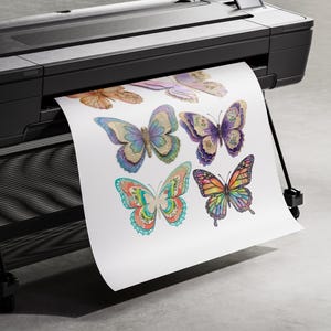 Puede incluir: Una impresora de gran formato negra que expulsa una hoja de papel blanca con una colecci&oacute;n de ilustraciones de mariposas coloridas. Las mariposas muestran patrones intrincados en tonos azul, morado, naranja y verde con alas detalladas.