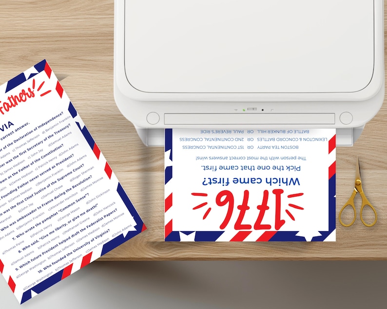 Puede incluir: Se muestra una impresora con una tarjeta de juego de trivia impresa. La tarjeta tiene un dise&ntilde;o rojo, blanco y azul con el texto "Which came first? 1776". Una segunda tarjeta est&aacute; sobre la mesa con preguntas sobre los Padres Fundadores.