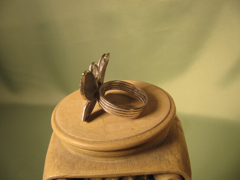 May include: Silver ring with a butterfly design. The ring is made of multiple bands and has a detailed butterfly design.