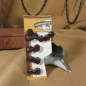 May include: A card with six brown hexagonal buttons on it. The card is labeled "Fashionable" and has a copyright symbol with the year 1958.