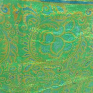 Może przedstawiać: Zielony materiał z wzorem paisley w kolorze złotym i niebieskim.