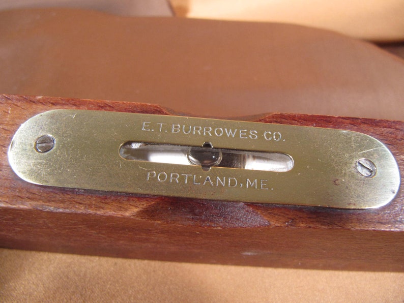 May include: A brass level with the inscription "E.T. BURROWES CO. PORTLAND, ME."