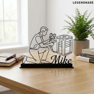 May include: Black metal desk ornament featuring a line drawing of an HVAC technician kneeling and working on an air conditioning unit. The name "Mike" is written in cursive below the figure. The word "LEGENDNADE" is written in the top right corner.