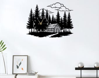 May include: Black wall clock featuring a forest scene with a cabin and trees. The clock face has gold hands and a minimalist design. The word "LEGENDNADE" is printed at the top left.