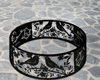 May include: Black metal ring with a laser-cut design featuring birds perched on flowering branches. The ring has decorative text and a heart shape. The word "LEGENDNADE" is at the top.