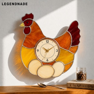 May include: A stained glass chicken-shaped wall clock with a cream-colored clock face. The clock features a red comb, yellow beak, and a body of orange and yellow glass. The clock has three egg-shaped glass pieces below the clock face. The brand name "LEGENDNADE" is at the top.