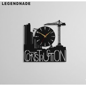 Puede incluir: Reloj de pared negro con temática de construcción, con una silueta de paisaje urbano. El reloj presenta una grúa, edificios y la palabra "CONSTRUCTION" en la parte inferior. Las manecillas son doradas y los números son blancos.