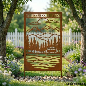May include: A rectangular, rust-coloured metal sign with the words "WILDERNESS JOURNEY" cut out at the top. The sign features a mountain and forest scene with a camper van. The sign is placed in a garden setting.