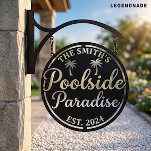 May include: A circular black metal hanging sign featuring the text THE SMITH'S Poolside Paradise EST. 2024 with two palm tree icons. The sign is suspended by chains from a black metal bracket attached to a stone pillar, displaying a clean design.