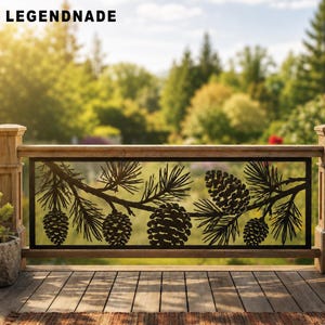 May include: A rectangular black metal railing insert featuring a laser-cut design of pine branches with multiple pinecones. The decorative panel is framed by a wooden railing structure and displays the text LEGENDNADE in the top left corner.