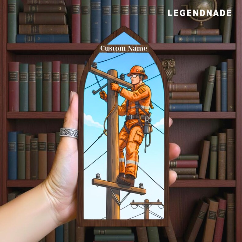 May include: A wooden plaque with a custom name area, featuring an illustration of a lineman working on a power pole. The lineman is wearing orange safety gear against a blue sky background. The plaque has a dark brown frame and the text "LEGENDNADE".