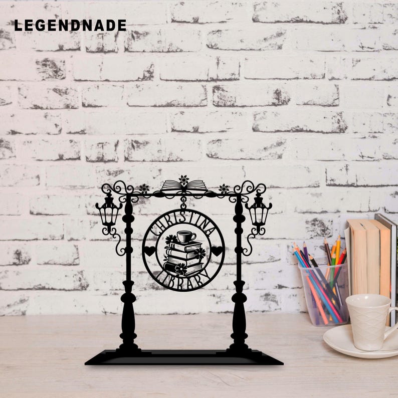 May include: Black metal sign with the text "CHRISTINA LIBRARY" in a circular design, featuring a stack of books and a teacup. The sign has decorative lanterns and floral accents, perfect for a home library or reading nook.