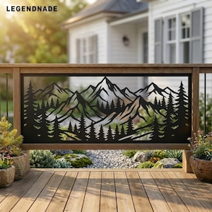 May include: A black metal railing panel featuring a laser-cut design of a mountain range with pine trees. The rectangular panel is framed in wood and displays the text LEGENDNADE in the top left corner, set against a blurred outdoor home background.