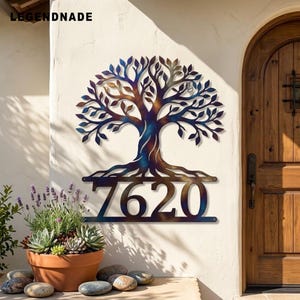 May include: A metal wall sign featuring a tree silhouette with a heat-treated iridescent finish in shades of blue, purple, and bronze. The design includes the house number 7620 integrated into the base of the tree trunk and roots.