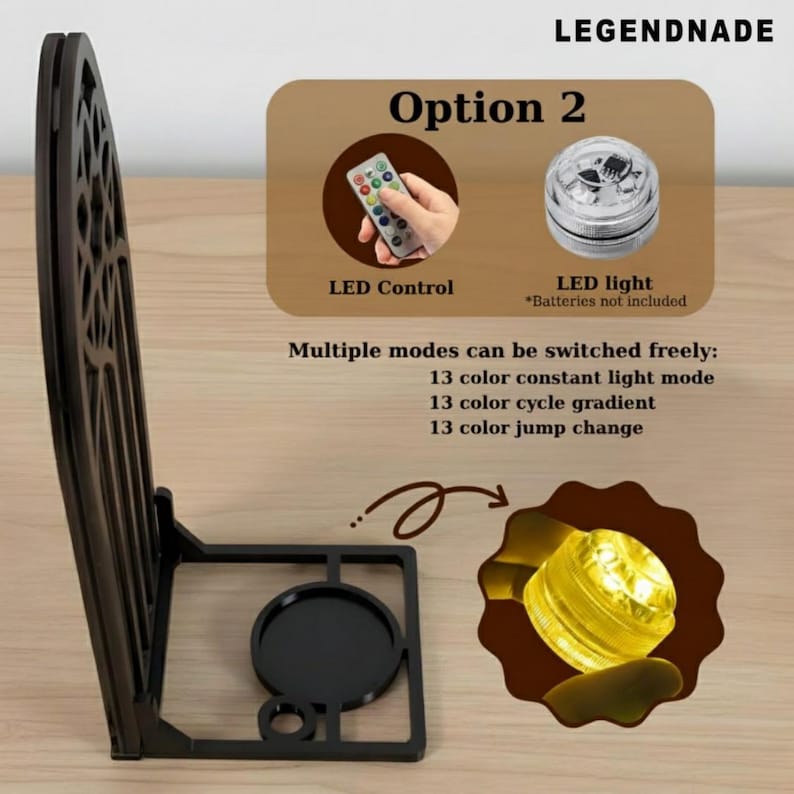 May include: A black, decorative LED light stand with a cut-out design. The image includes a remote control and an LED light, with text indicating multiple color modes. The stand is designed to hold a light.