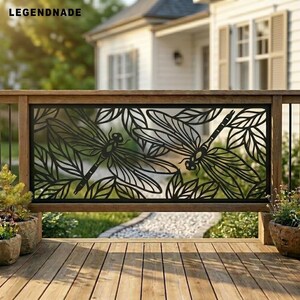 Puede incluir: Un panel de barandilla de metal negro con un diseño cortado con láser de dos libélulas rodeadas de patrones de follaje detallados. El panel rectangular está enmarcado en madera y muestra el texto LEGENDNADE arriba a la izquierda.