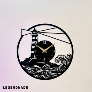 May include: Black and white lighthouse wall clock with a circular design. The clock features a lighthouse, waves, and a black clock face with gold hands. The text "LEGENDNADE" is at the bottom.