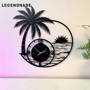Puede incluir: Reloj de pared de metal negro con diseño de palmera, sol y océano. La esfera del reloj es redonda con manecillas doradas y números negros. La palabra "LEGENDNADE" está en la parte superior. Una pieza decorativa para un tema costero o tropical.
