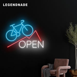 May include: A neon sign with a blue bicycle outline above a red line and the word "OPEN" in white. The sign is against a black background with the word "LEGENDNADE" in white at the top left.