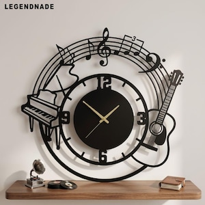 May include: Black wall clock featuring a piano and guitar silhouettes, with musical notes and a treble clef. The clock has a black face with gold hands. The clock is mounted on a white wall. The clock is a decorative item.