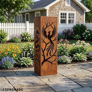May include: A tall, rectangular, weathered metal garden sculpture. The sculpture features cut-out designs of a dragon and a phoenix with tree branches. The sculpture is set on a stone patio with a white picket fence and a house in the background. The word LEGENDNADE is at the bottom.