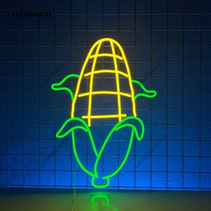 Può includere: Un cartello al neon a forma di pannocchia di mais con foglie verdi e una pannocchia gialla. Il cartello è acceso e brilla.