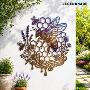 May include: A metal wall art piece featuring a large central bee, three smaller bees, and a honeycomb pattern. The design includes floral elements and dripping honey motifs with a gradient color finish. The text LEGENDNADE is visible at the top.