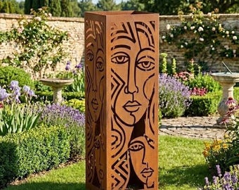 May include: A tall, rectangular, weathered metal garden sculpture featuring cut-out faces. The brown sculpture stands in a green garden with flowers and trees. The word "LEGENDNADE" is visible in the top left corner.