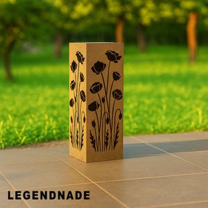 May include: A rectangular, light brown wooden lantern with black poppy flower cutouts. The lantern is standing on a tiled surface with a green grassy background. The text "LEGENDNADE" is at the bottom.