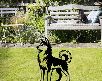 May include: Black metal husky dog silhouette garden art. The decorative yard art features a detailed cutout design of a husky dog standing on a green lawn. The dog is facing left with its tail curled up. The background includes a wooden bench and a white chair.