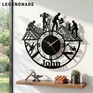May include: A black metal wall clock featuring a silhouette design of construction workers on a roof, with the name John at the bottom. The clock face has gold hands and numbers 3, 6, 9, and 12. The text LEGENDNADE is visible in the top left corner.