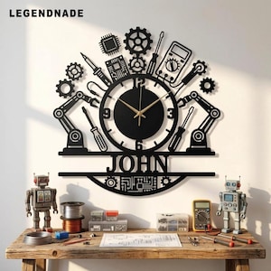 May include: A black wall clock featuring a central circular face with gold hands, surrounded by mechanical icons including gears, robotic arms, a multimeter, and tools. The name JOHN is cut out in the center, with circuit board patterns below.