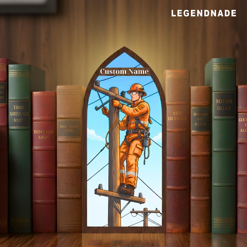May include: A wooden decorative piece featuring an illustration of an electrician working on a power line, set against a blue sky. The text "Custom Name" is above the illustration. The piece is framed by a collection of vintage books, with the word "LEGENDNADE" at the top.