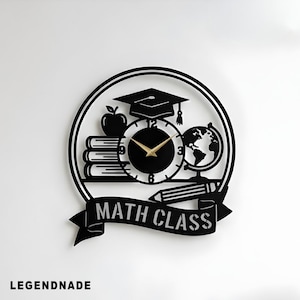 May include: Black metal wall clock with a school theme. The clock features a graduation cap, books, an apple, a globe, and a pencil. The words "MATH CLASS" are displayed on a banner below the clock face. The clock hands are gold.
