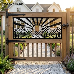 May include: A wooden gate featuring a black metal insert with a laser-cut design of a sun rising over mountain peaks and pine trees. The text LEGENDNADE is visible in the upper left corner. The gate has black metal hinges and a latch.