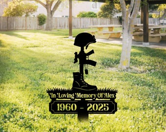 May include: Black metal memorial stake featuring a silhouette of a military helmet, rifle, and combat boot. The stake includes a banner with the text "In Loving Memory Of Alex" and the years "1960 - 2025". The word "LEGENDNADE" is in the top left corner.
