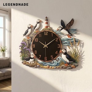 May include: A wall clock featuring a round black face with gold numbers and hands. The frame depicts a coastal scene with puffins, a lighthouse, waves, rocks, and purple flowers. The text LEGENDNADE is printed in the upper left corner.