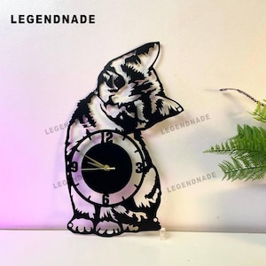 May include: Black and white cat-shaped wall clock. The clock face is a circle with black numbers and gold hands. The cat's body is cut out, revealing the wall behind it. The brand name "LEGENDNADE" is at the top.