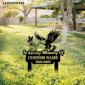 Puede incluir: Estaca de jardín conmemorativa de metal negro con una silueta de un águila, flores y una mariposa. La estaca tiene un letrero que dice "In Loving Memory Of CUSTOM NAME 2020-2025".