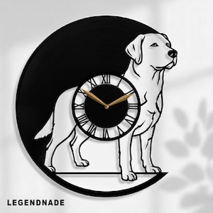 Könnte beinhalten: Schwarz-weiße Labrador Retriever Silhouette Uhr aus einer Schallplatte. Das Zifferblatt hat römische Ziffern und goldfarbene Zeiger. Der Text "LEGENDNADE" befindet sich unten.