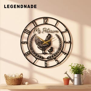 May include: Black metal wall clock with a chicken and chick design, the clock hands are gold. The clock face has Roman numerals and the name "Mr. Peterson" is above the chicken. The brand name "LEGENDNADE" is at the top left.
