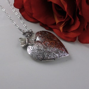 Hand-painted antique silver heart-shaped locket 42 mm.   Decorated with a cute antique silver butterfly and is hand-painted black.  Hanging from a silver chain. Free photo service.