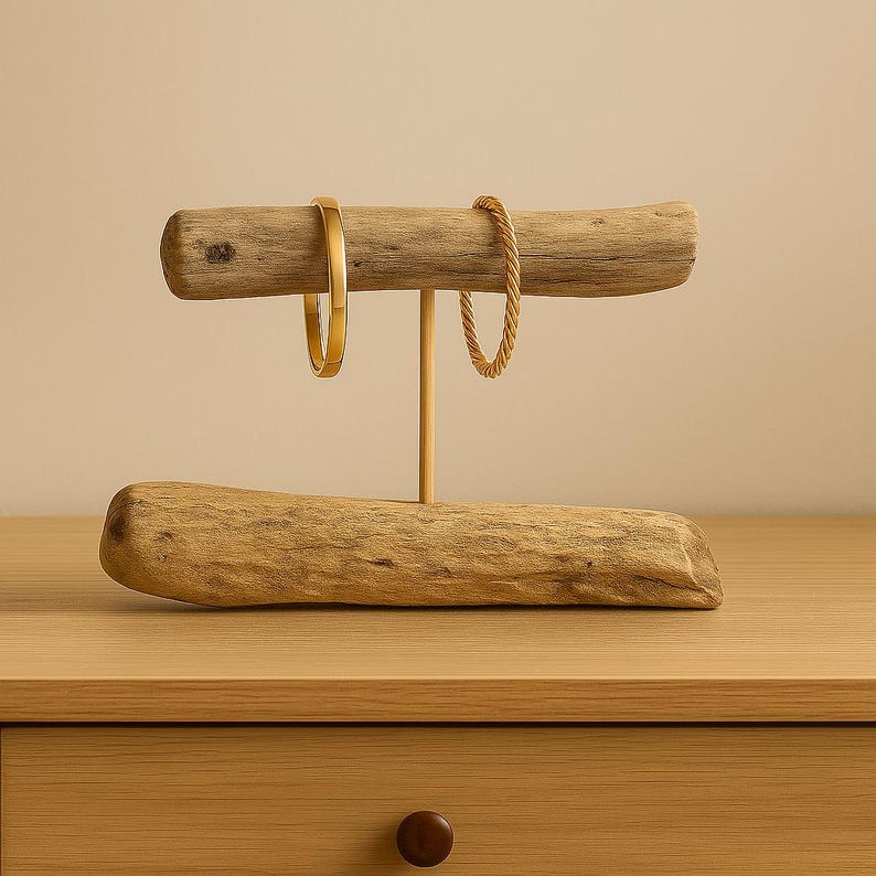 Close-up of multiple bracelets hanging on the driftwood rod, showing how jewelry wraps around the natural wood grain.