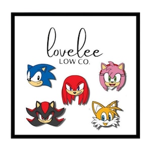 Può includere: Cinque volti di personaggi dei cartoni animati colorati, tra cui Sonic the Hedgehog, Knuckles, Amy Rose, Shadow the Hedgehog e Tails, sono visualizzati su uno sfondo bianco con il testo "lovelee LOW CO."