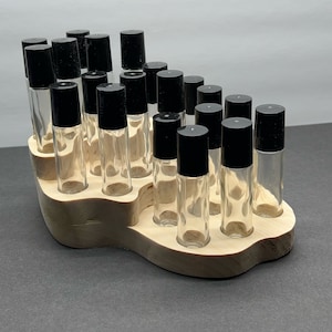 May include: A wooden roller bottle holder with 20 clear glass roller bottles with black lids.