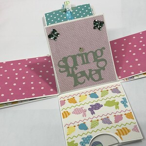 May include: A pink and white polka dot paper box with a light pink panel that says "spring fever" in green letters. The box is decorated with butterflies and has a light blue and white polka dot panel on the top.