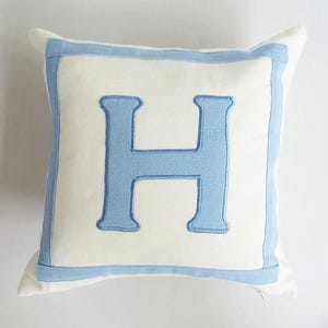 Almofada com letras, branca e azul-claro, capa de almofada com iniciais, capa de almofada com alfabeto, decoração em cúpula. Almofada personalizada. Almofada para presente, modelo personalizado.